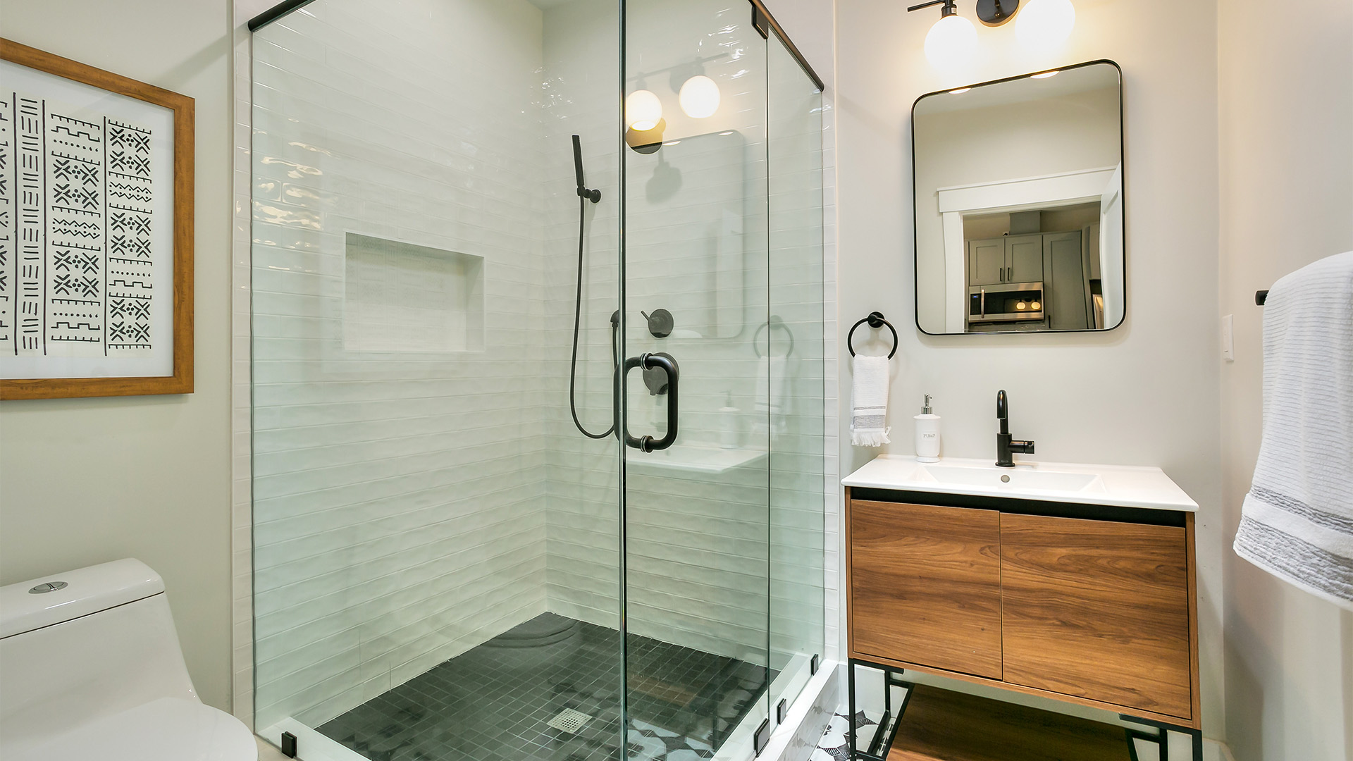 glass-shower-white-tile-walls-black-tile-floor-bathroom
